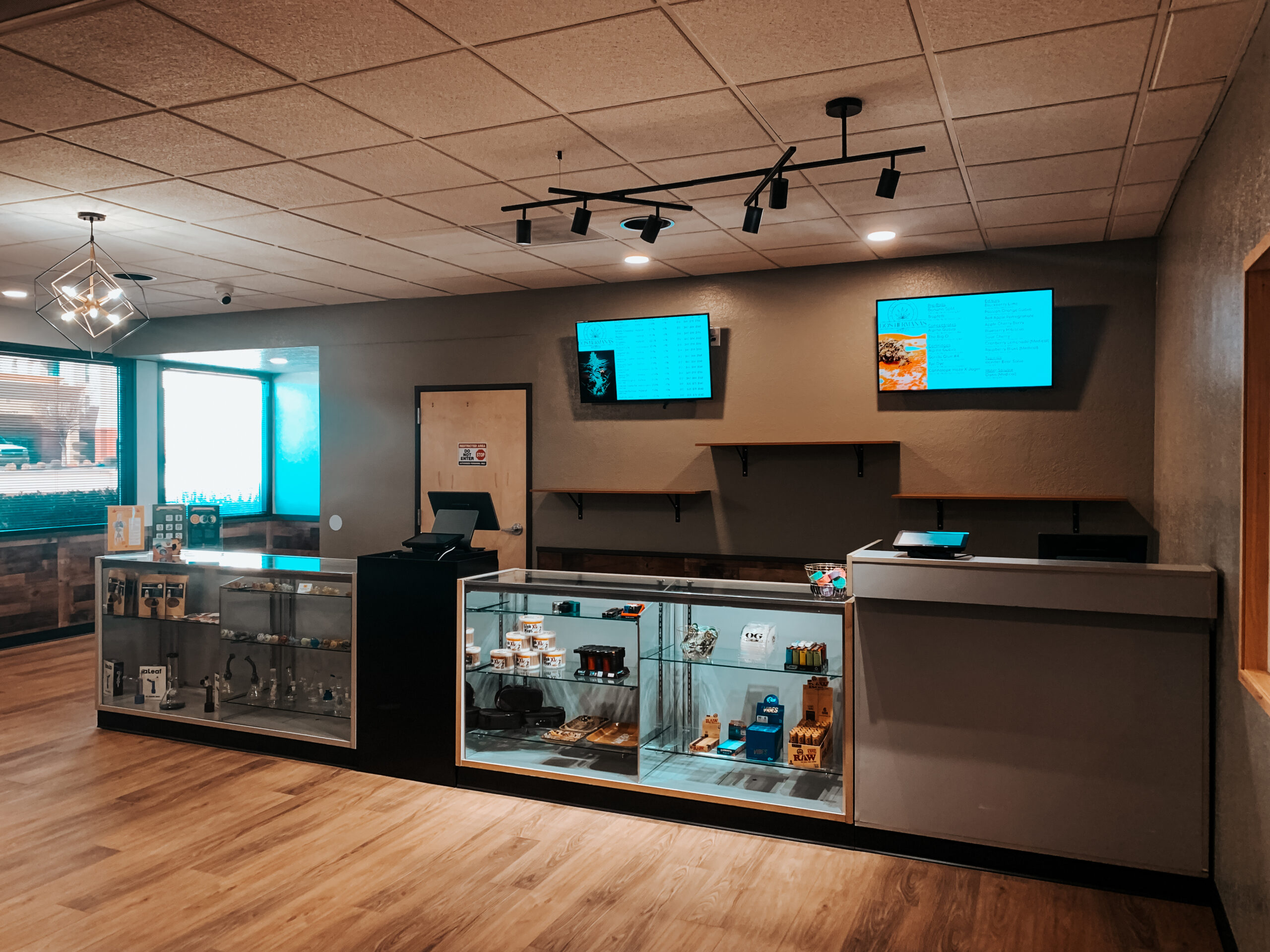 Product display cases and digital menus inside Dos Hermanas dispensary on Route 66 in Santa Rosa, New Mexico
